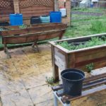 Photo of an accessible allotment, with wider pathways for walking and wheelchairs as well as lower potting plants.